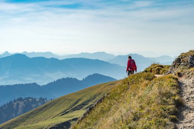 Güzel bir son sınıf öğrencisi, sonbaharda yürüyüş yapıyor, Oberstaufen yakınlarındaki Nagelfluh zincirinin tepesinde, Allgaeu Area, Bavyera, Almanya, arka planda Hochgrats zirvesi