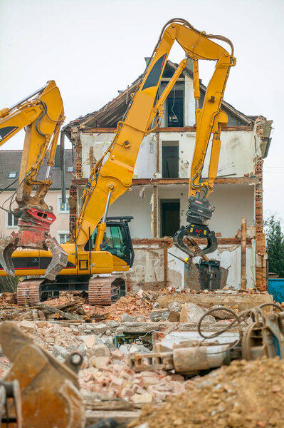 Excavator demolishing an old residential building