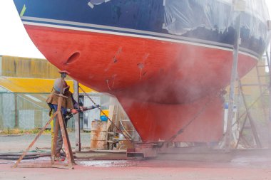  Bir teknede çalışan bir cüce ve bir yelkenlinin çürümüş gövdesini patlatıyor.