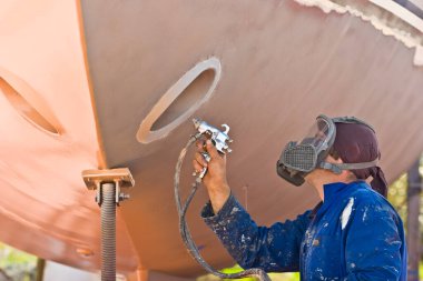 Geminin gövdesini boyarken sprey boyacı.