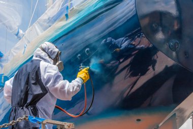 Geminin gövdesini boyarken sprey boyacı.