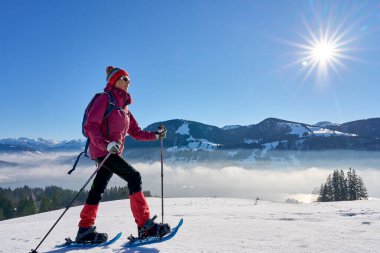   Almanya, Bavyera, Immenstadt 'ın yukarısındaki Allgau Alplerinde kar ayakkabısı giyen hoş ve aktif bir son sınıf öğrencisi.                             