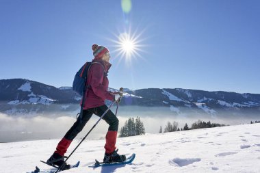   Almanya, Bavyera, Immenstadt 'ın yukarısındaki Allgau Alplerinde kar ayakkabısı giyen hoş ve aktif bir son sınıf öğrencisi.                             