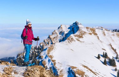     Bregenz Wald dağlarının, Hochgrat 'ın, Steibis' in, Bavyera Alpleri 'nin, Almanya' nın üzerindeki sis denizinin üzerinde Nagelfluh zincirinde kar ayakkabısı giyen son sınıf güzeli bir kadın.                           