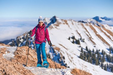     Bregenz Wald dağlarının, Hochgrat 'ın, Steibis' in, Bavyera Alpleri 'nin, Almanya' nın üzerindeki sis denizinin üzerinde Nagelfluh zincirinde kar ayakkabısı giyen son sınıf güzeli bir kadın.                           