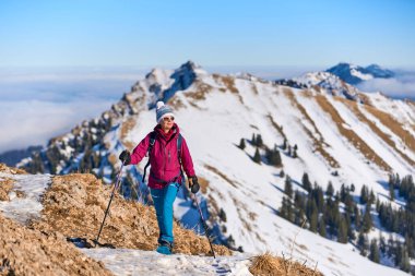     Bregenz Wald dağlarının, Hochgrat 'ın, Steibis' in, Bavyera Alpleri 'nin, Almanya' nın üzerindeki sis denizinin üzerinde Nagelfluh zincirinde kar ayakkabısı giyen son sınıf güzeli bir kadın.                           