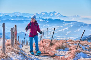    Üst kattaki Nagelfluh zincirinde kar ayakkabısı giyen hoş bir kadın Bregenz Wald dağlarının üzerinden İsviçre 'deki Saentis Dağı' na, Bavyera Alpleri 'ne, Almanya' ya harika bir manzarası var.                            