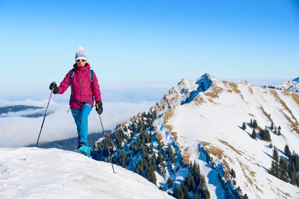     Bregenz Wald dağlarının, Hochgrat 'ın, Steibis' in, Bavyera Alpleri 'nin, Almanya' nın üzerindeki sis denizinin üzerinde Nagelfluh zincirinde kar ayakkabısı giyen son sınıf güzeli bir kadın.                           