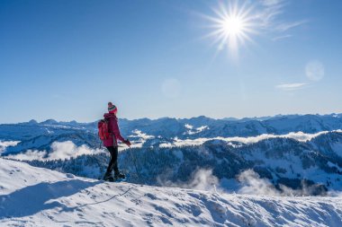 Bregenz Wald dağlarının, Hochgrat 'ın, Steibis' in, Bavyera Alpleri 'nin, Almanya' nın üzerindeki sis denizinin üzerinde Nagelfluh zincirinde kar ayakkabısı giyen son sınıf güzeli bir kadın.