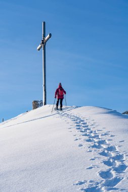 Bregenz Wald dağlarının, Hochgrat 'ın, Steibis' in, Bavyera Alpleri 'nin, Almanya' nın üzerindeki sis denizinin üzerinde Nagelfluh zincirinde kar ayakkabısı giyen son sınıf güzeli bir kadın.