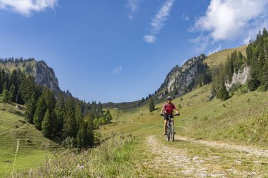 Avusturya 'nın Vorarlberg kentindeki Bregenzer Wald dağ sırasındaki Winterstaude zirvesinin aşağısındaki Schreiber Sattel' e elektrikli dağ bisikletiyle giden son sınıf öğrencisi hoş bir kadın.