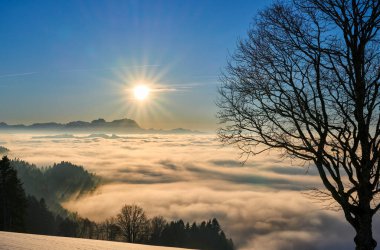        Avusturya 'nın Vorarlberg kentindeki karlı Bregenzer Wald bölgesinde gün batımı. İsviçre' deki Saentis Dağı 'nın üzerinde, Avusturya' nın Sulzberg kentinde, manzara.                        