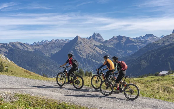 Avusturya, Vorarlberg, Mellau yakınlarındaki Bregenz Wald dağlarının sonbahar atmosferinde dağ bisikletlerine binen üç mutlu yetişkin.