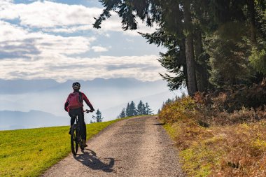 Allgaeu Alplerinde elektrikli dağ bisikleti süren siluet gibi bir kadın Oberstaufen yakınlarındaki Bregenz Wald Dağları, Vorarlberg İsviçre