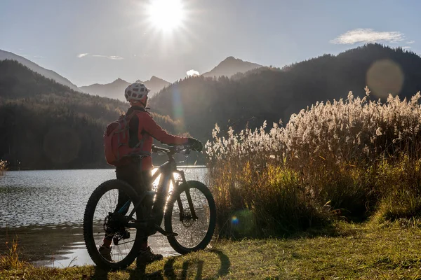 Senior Woman Electric Mountain Bike Bright Backlit Sun Shore Lake — Stock Photo, Image