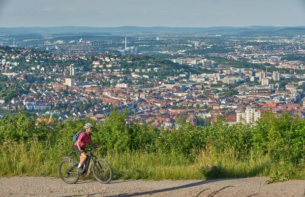 ドイツのバーデン ヴュルテンベルク州シュトゥットガルト市の丘の上のツアーで電動マウンテンバイクと素敵なアクティブシニア女性 — ストック写真