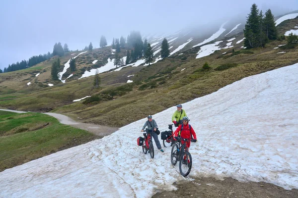 Group Three Active Seniors Riding Electric Mountain Bikes Crossing Snow — Φωτογραφία Αρχείου