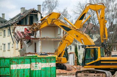 Ağır kazıcı eski bir konut binasını yıkıyor.