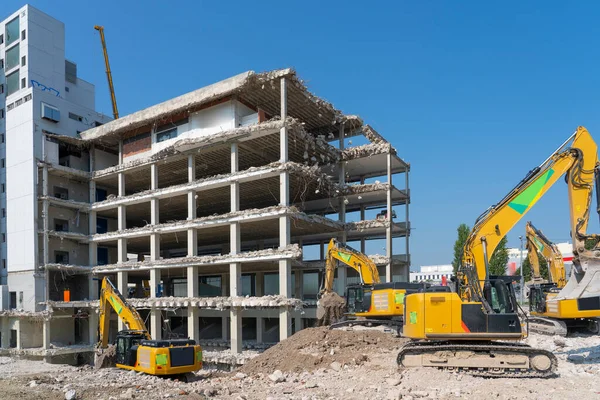 Excavators demolishing an old commercial business house building