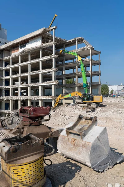 Excavators demolishing an old commercial business house building