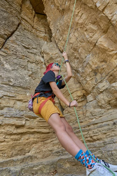 Teenage girl securing her climbing partner in a difficult rock climbing tour by a securing rope systemin Hessigheim, Baden-Wuerttemberg, Germany