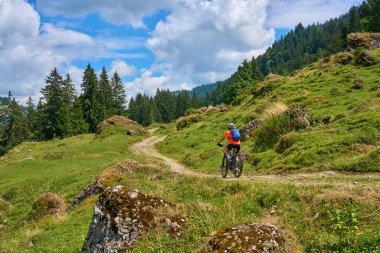 nice senior woman riding her electric mountain bike in the Bregenz Forest mountains near Hittisau, Vorarlberg Austria
