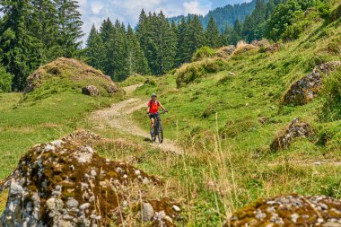 nice senior woman riding her electric mountain bike in the Bregenz Forest mountains near Hittisau, Vorarlberg Austria