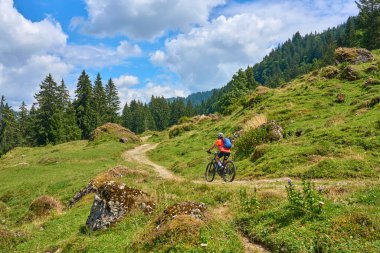 nice senior woman riding her electric mountain bike in the Bregenz Forest mountains near Hittisau, Vorarlberg Austria