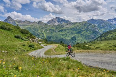 nice active senior woman riding her electric mountain bike in the silvretta mountain range near Gaschurn, Tyrol, Austria