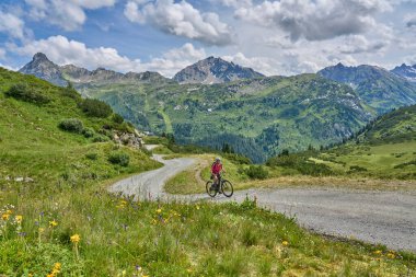 nice active senior woman riding her electric mountain bike in the silvretta mountain range near Gaschurn, Tyrol, Austria