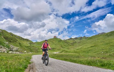 nice active senior woman riding her electric mountain bike in the silvretta mountain range near Gaschurn, Tyrol, Austria