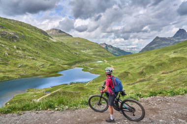 nice active senior woman riding her electric mountain bike in the silvretta mountain range near Gaschurn, Tyrol, Austria