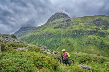nice active senior woman riding her electric mountain bike in the Jamtal Valley, silvretta mountain range near Gaschurn, Tyrol, Austria