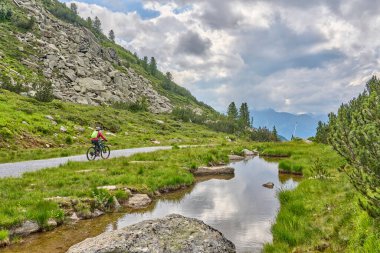 nice active senior woman riding her electric mountain bike in the silvretta mountain range near Gaschurn, Tyrol, Austria