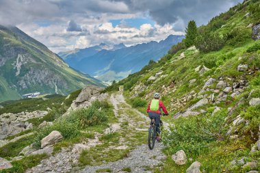nice active senior woman riding her electric mountain bike in the silvretta mountain range near Gaschurn, Tyrol, Austria