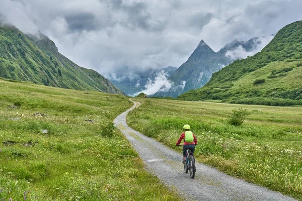 nice active senior woman riding her electric mountain bike in the silvretta mountain range near Gaschurn, Tyrol, Austria