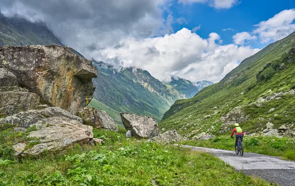 nice active senior woman riding her electric mountain bike in the Jamtal Valley, silvretta mountain range near Gaschurn, Tyrol, Austria