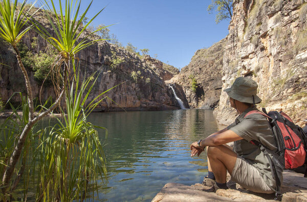 woman resting at the shore of a Rock pool at the Barramundi falls, Kakadu National Park, Northern Territory, Australia, one of the crocodile fre lakes in this area, where swimming is possible