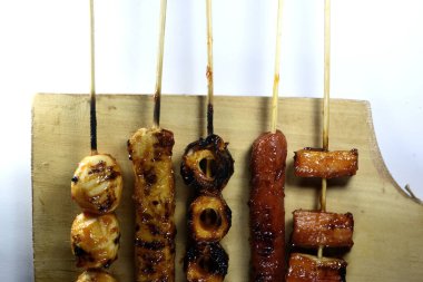 Endonezya sokak atıştırmalıkları, sosis, köfte, mantar, nugget vs. gibi beyaz arka planda izole edilmiş şeylerden oluşan çeşitli ızgara çeşitleri.