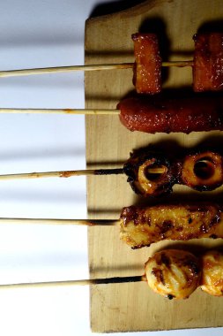 Endonezya sokak atıştırmalıkları, sosis, köfte, mantar, nugget vs. gibi beyaz arka planda izole edilmiş şeylerden oluşan çeşitli ızgara çeşitleri.