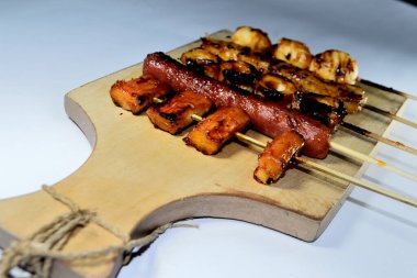 Endonezya sokak atıştırmalıkları, sosis, köfte, mantar, nugget vs. gibi beyaz arka planda izole edilmiş şeylerden oluşan çeşitli ızgara çeşitleri.