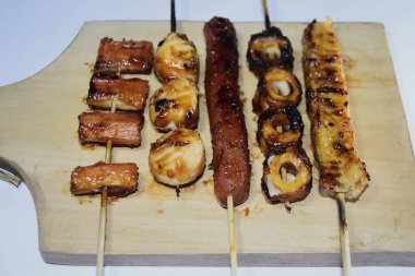 Endonezya sokak atıştırmalıkları, sosis, köfte, mantar, nugget vs. gibi beyaz arka planda izole edilmiş şeylerden oluşan çeşitli ızgara çeşitleri.