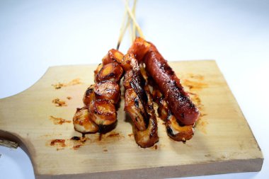 Endonezya sokak atıştırmalıkları, sosis, köfte, mantar, nugget vs. gibi beyaz arka planda izole edilmiş şeylerden oluşan çeşitli ızgara çeşitleri.