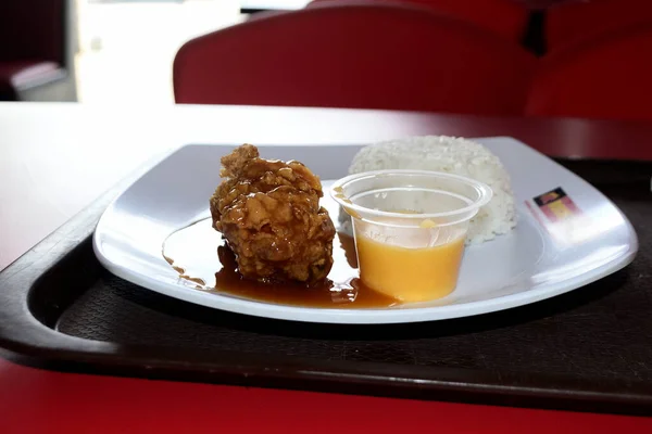 Fried chicken with spicy chili sauce on a white plate