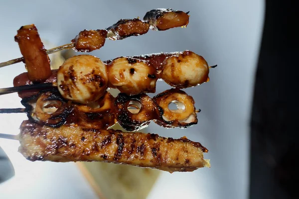 Endonezya sokak atıştırmalıkları, sosis, köfte, mantar, nugget vs. gibi beyaz arka planda izole edilmiş şeylerden oluşan çeşitli ızgara çeşitleri.