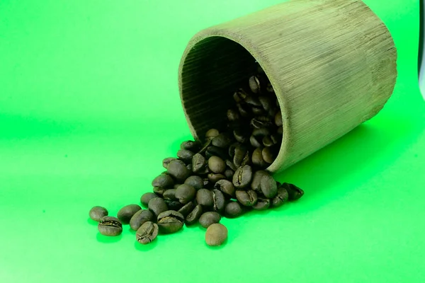 Kávová Zrna Bambusovém Skle Jsou Roztroušená Fotografie Zeleném Pozadí — Stock fotografie