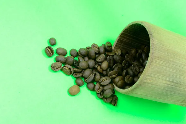 Koffiebonen Het Bamboe Glas Zijn Verspreid Foto Groene Achtergrond — Stockfoto