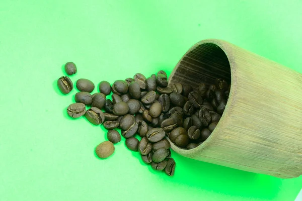 Koffiebonen Het Bamboe Glas Zijn Verspreid Foto Groene Achtergrond — Stockfoto