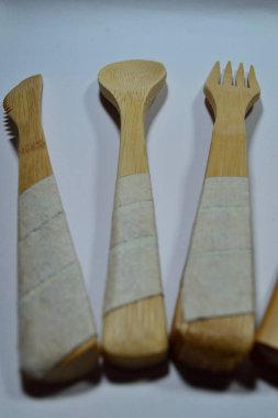 Saf beyaz arka planda bambudan yapılmış bir çatal bıçak seti.