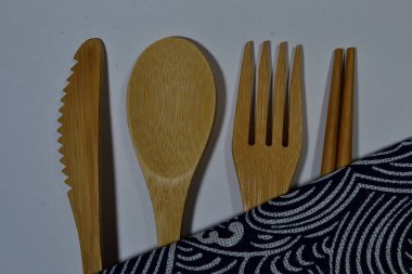 Saf beyaz arka planda bambudan yapılmış bir çatal bıçak seti.